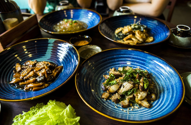 Traditional Vietnamese dishes served in ceramic bowls during Hoi An culinary experience tour